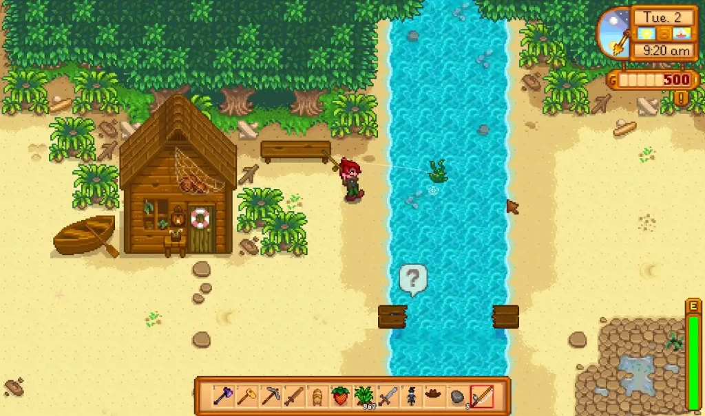 Stardew Valley’den piksel grafiklere sahip bir sahne. Oyuncu karakteri, tropik bitkilerle çevrili kumlu bir sahilde ahşap kulübenin yanında nehirde balık tutuyor. Ekranda oyun içi saat, para göstergesi ve eşya çubuğu da görülüyor.