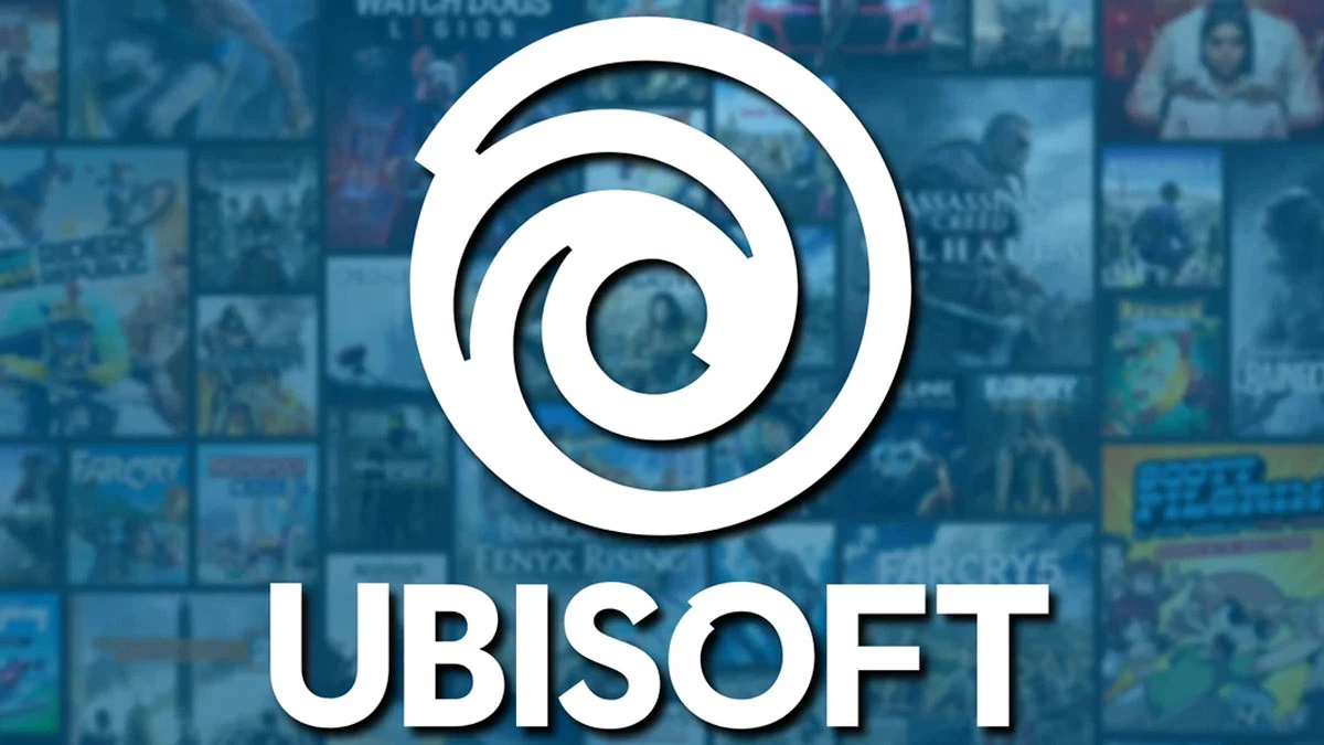 Mavi tonlarda bulanık bir oyun kütüphanesi arka planı üzerinde büyük beyaz Ubisoft logosu ve altında “UBISOFT” yazısı yer alıyor. Arka planda Assassin’s Creed, Far Cry ve diğer Ubisoft oyunlarına ait kapak görsellerinden oluşan bir mozaik bulunuyor.